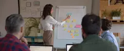 Manager presenting project strategy to coworkers, drawing hierarchy chart. Business colleagues in casual working together in contemporary office space. Presentation concept 